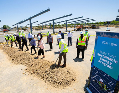Executives with hard hats and shovels breaking ground of solar project